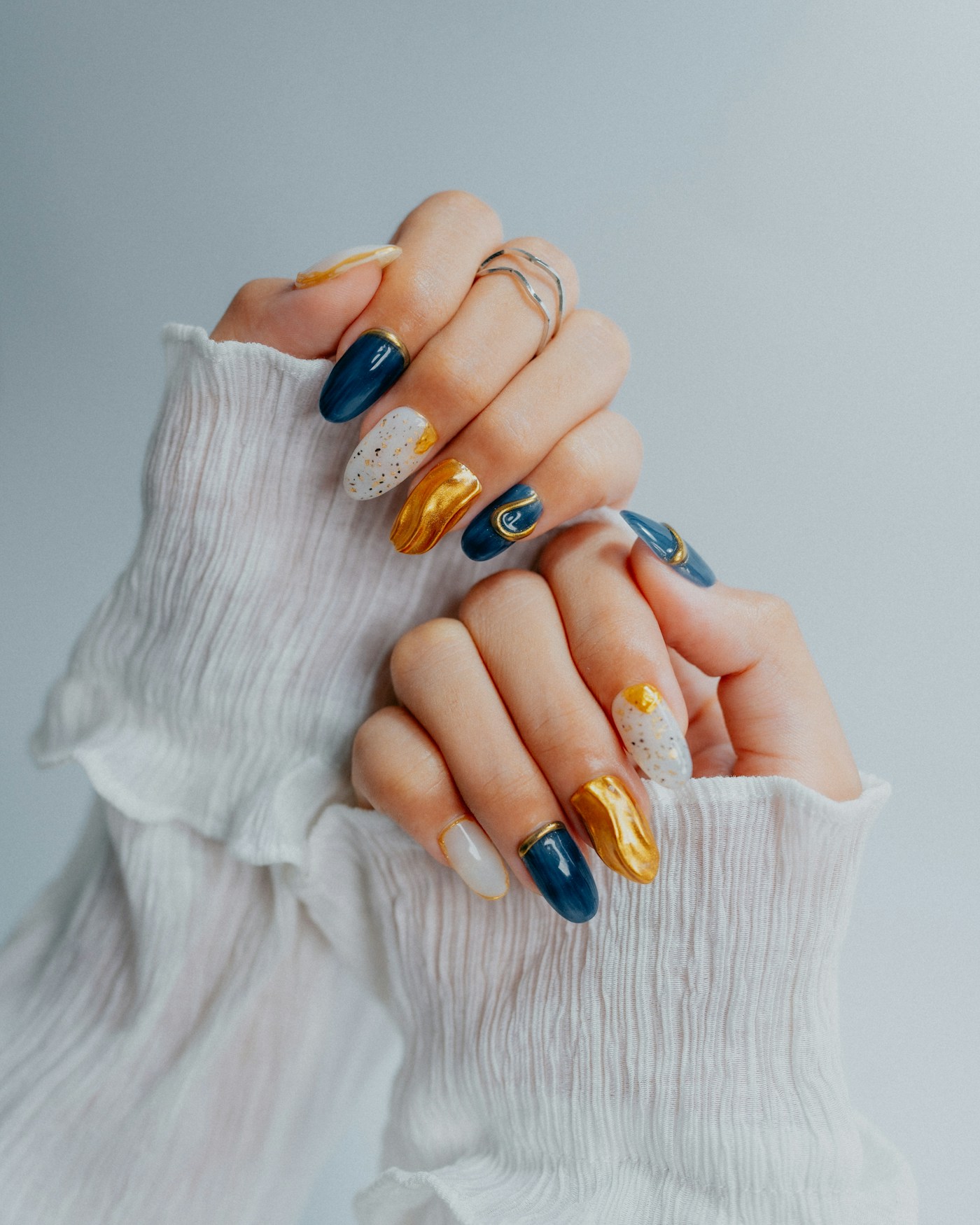 Unhas com arte em azul e dourado